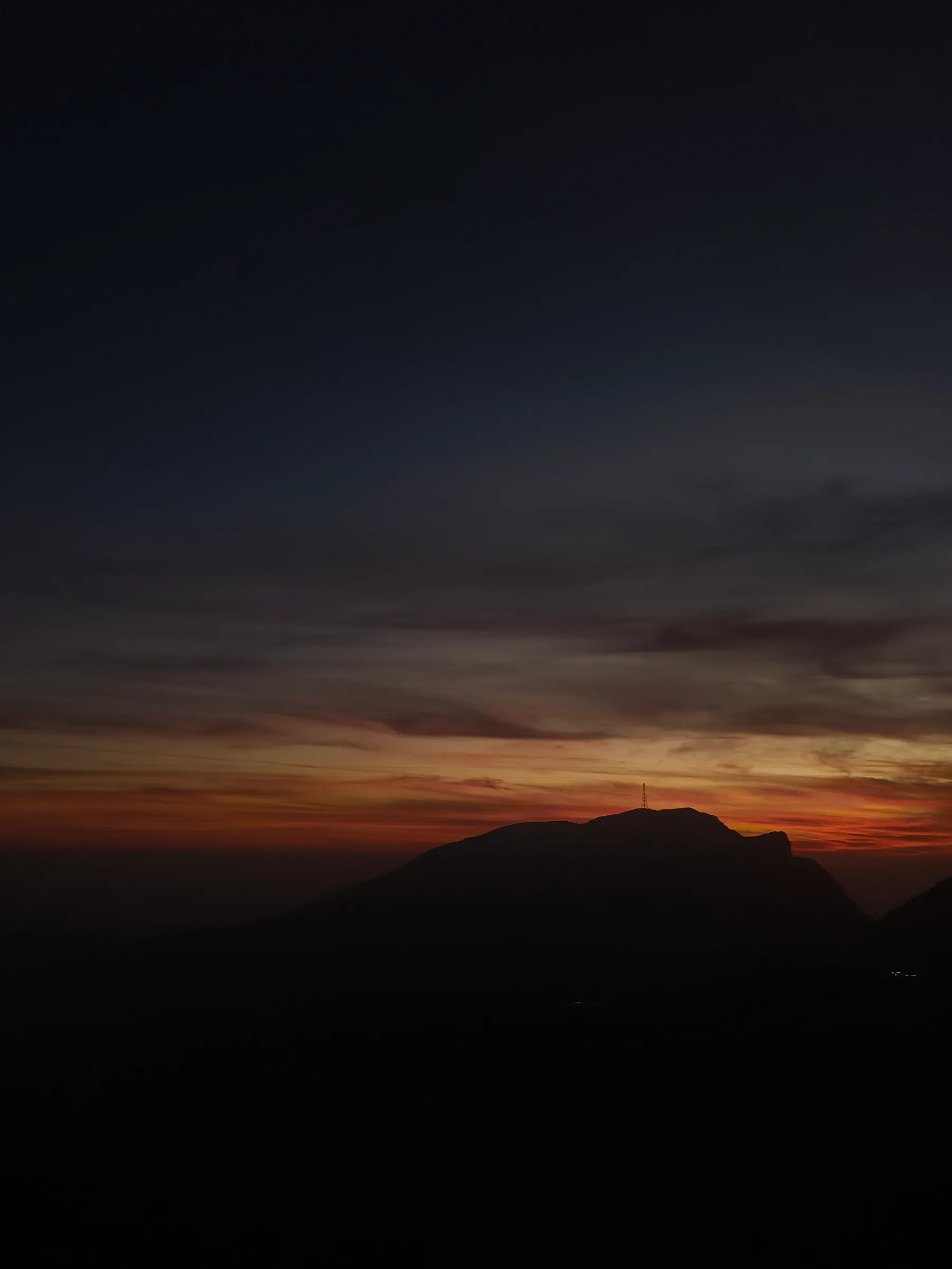 The mountain going dark, one mast on top